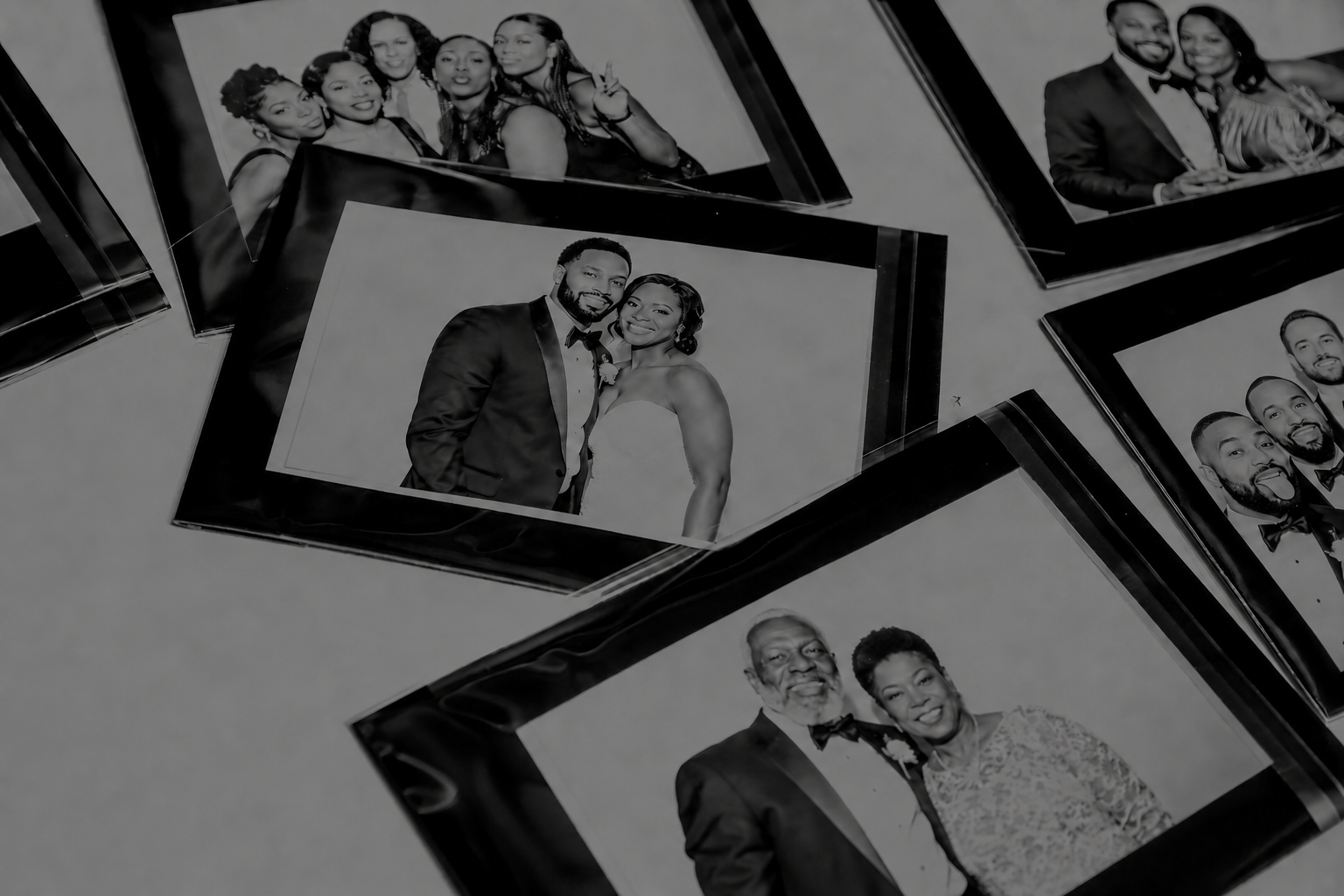 Black and white photo booth prints scattered on a table